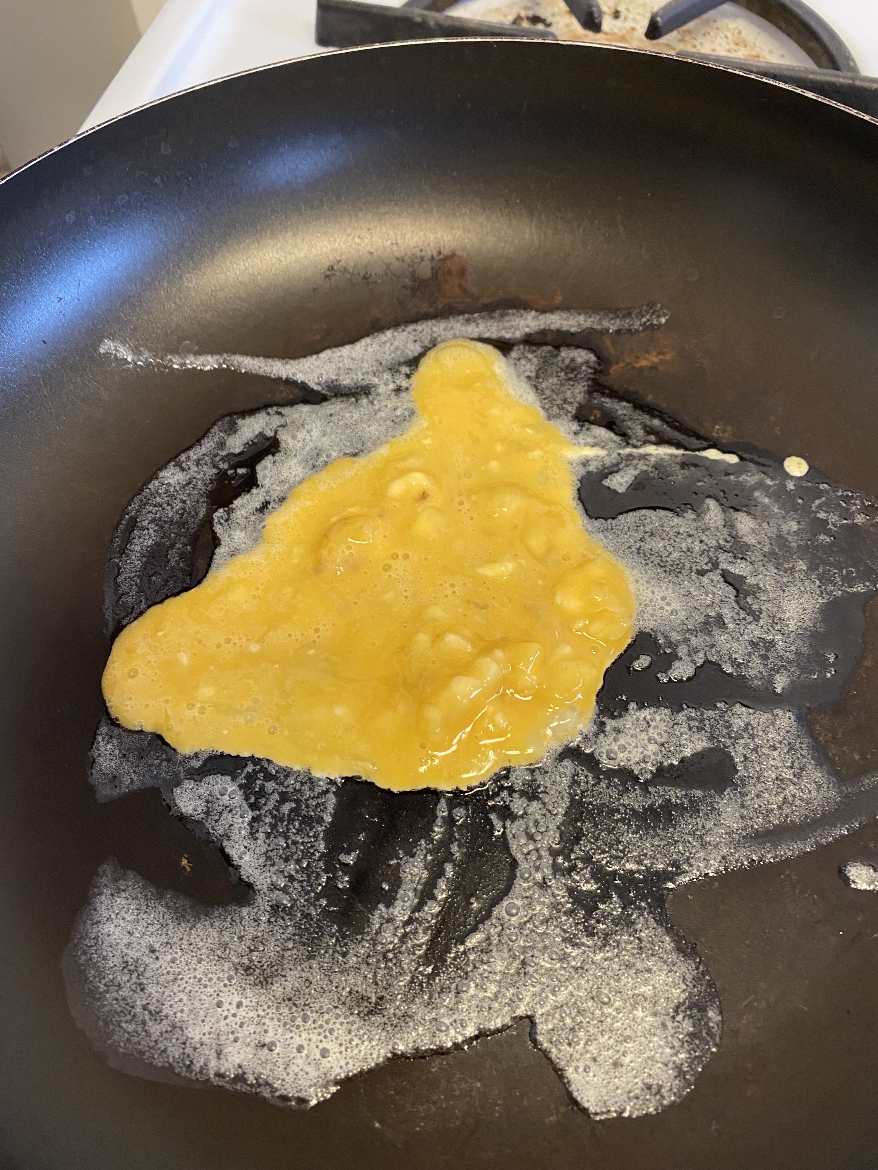 The pancake batter sizzling on the pan, running all over the place