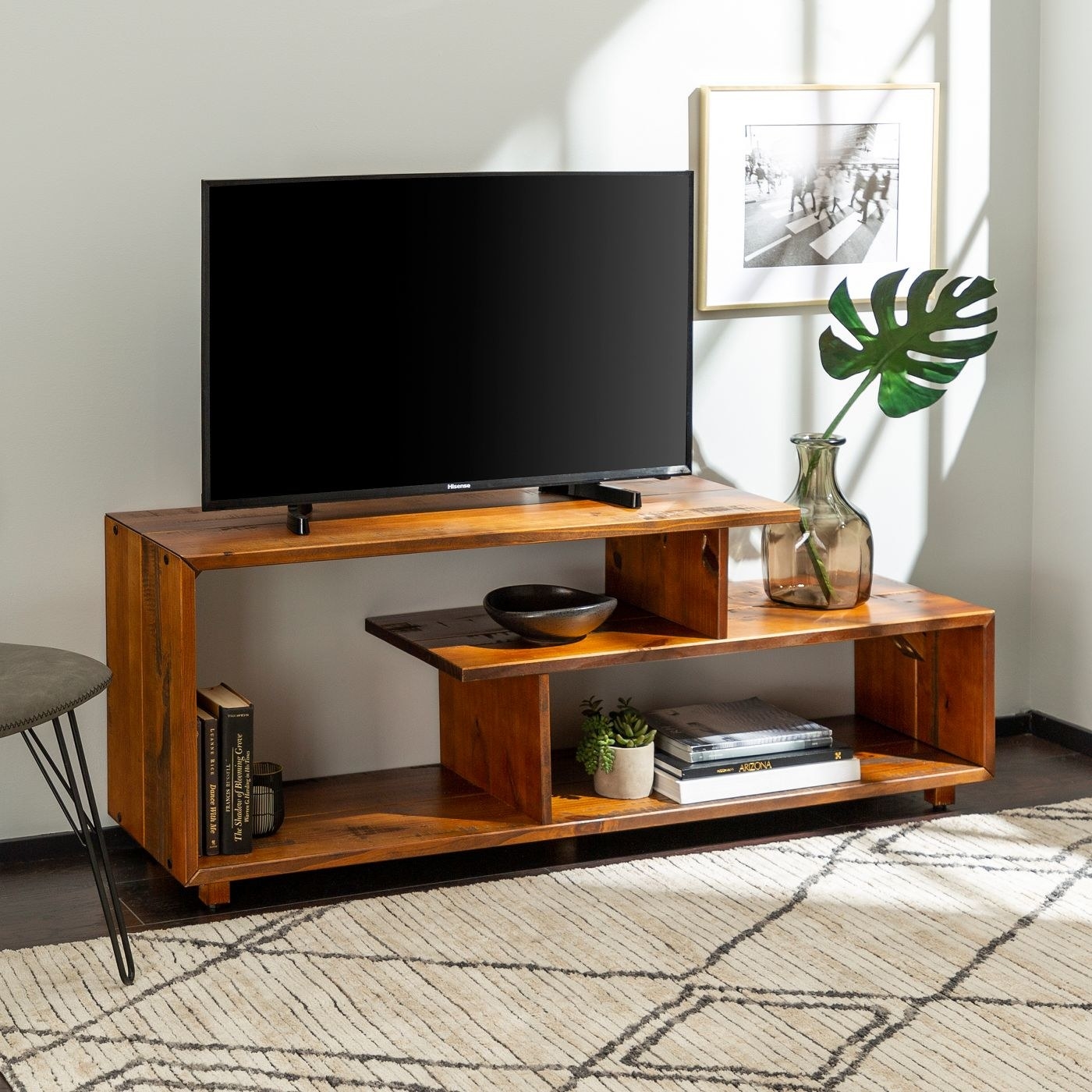 TV stand with a TV on it and items stored inside.