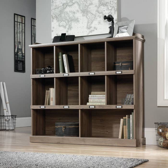The bookshelf in a living room with multiple items inside it