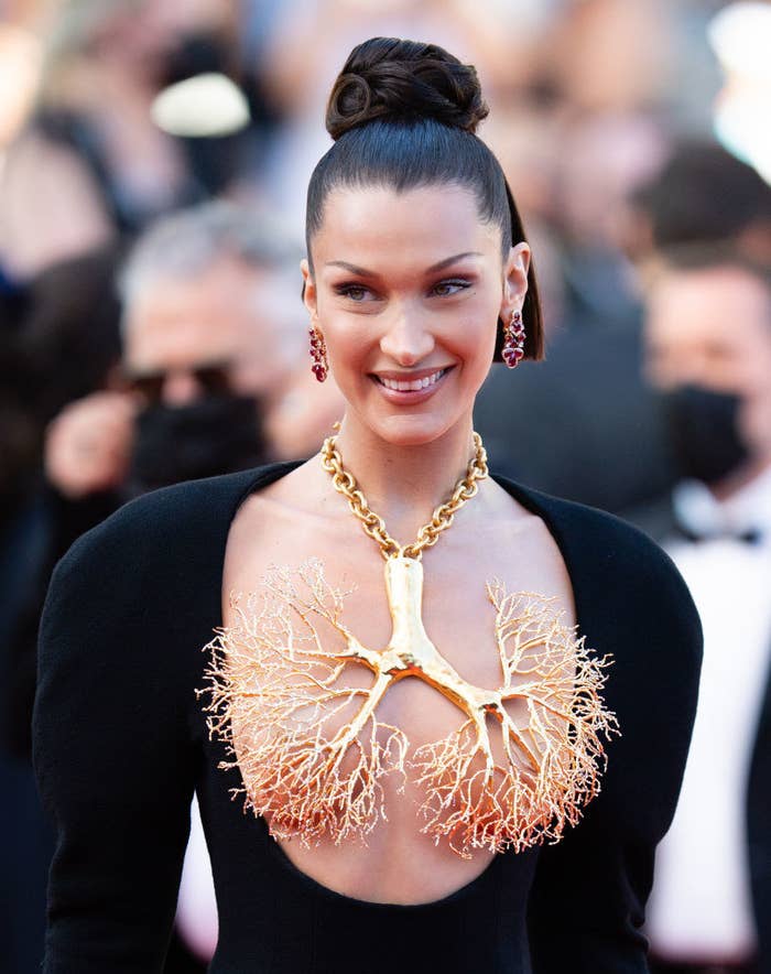 Bella Hadid smiling while posing in the dress