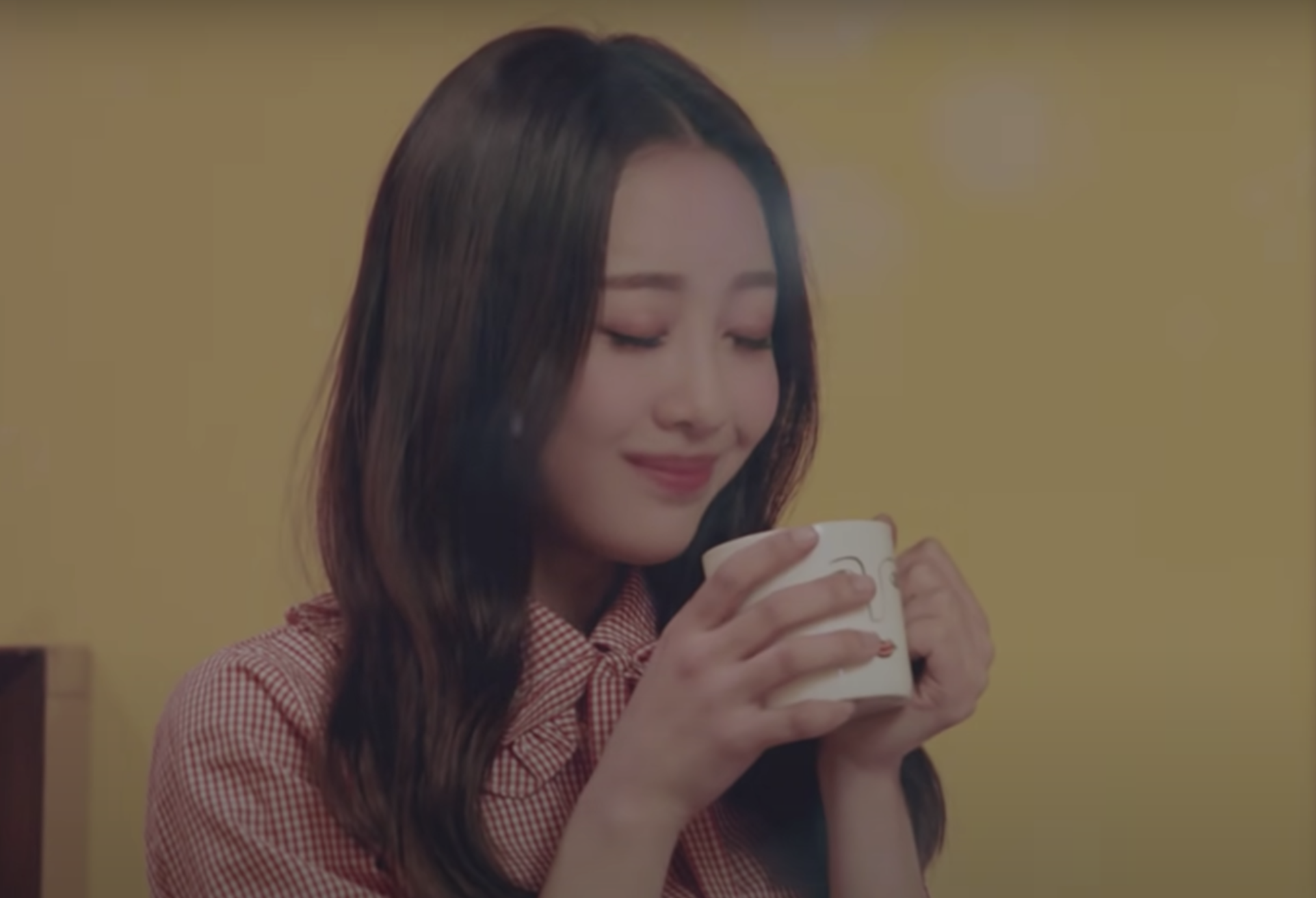 Chuu smiling to herself with holding a warm mug close to her face