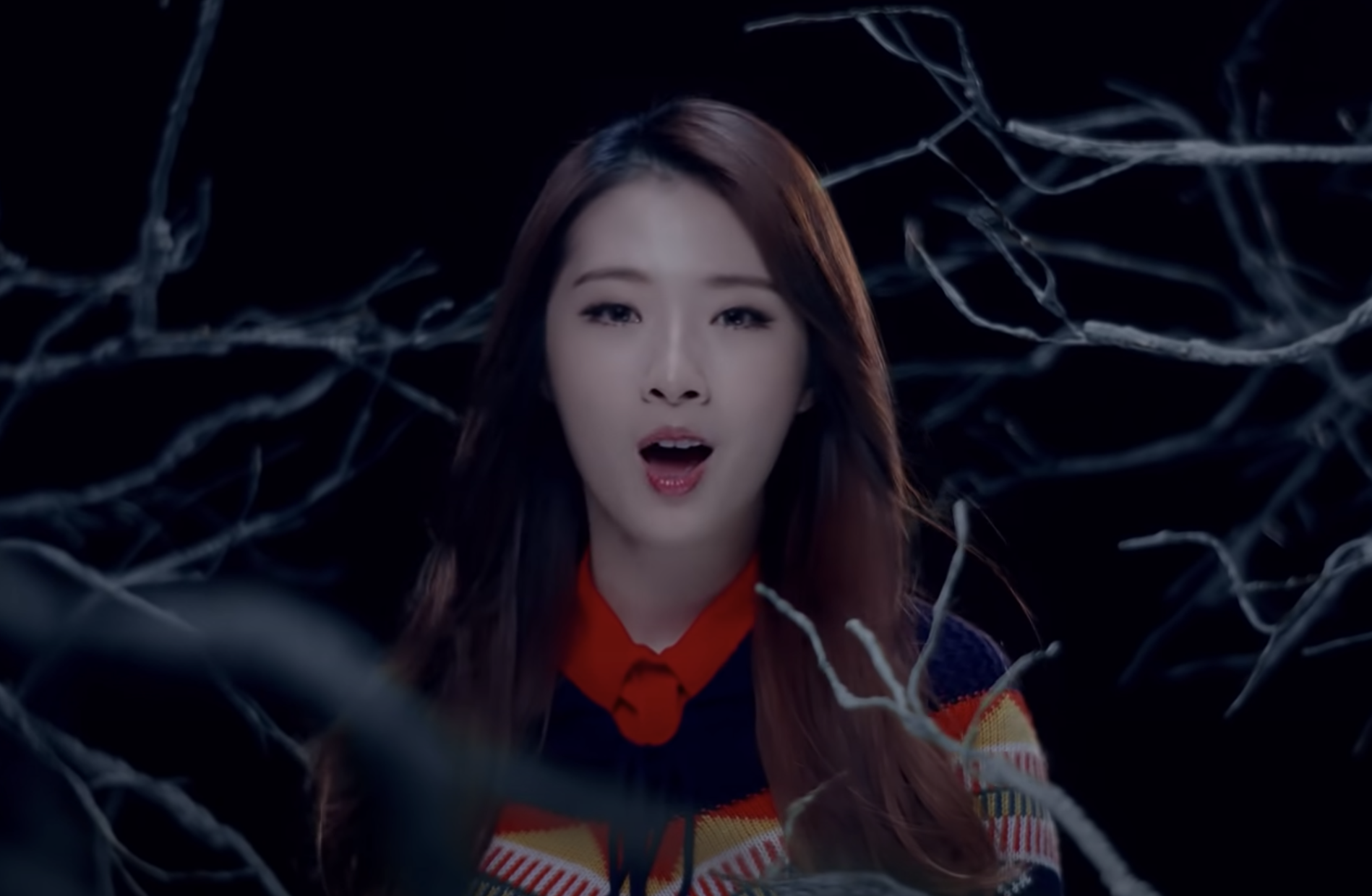 HaSeul sings in front of a bunch of tree branches
