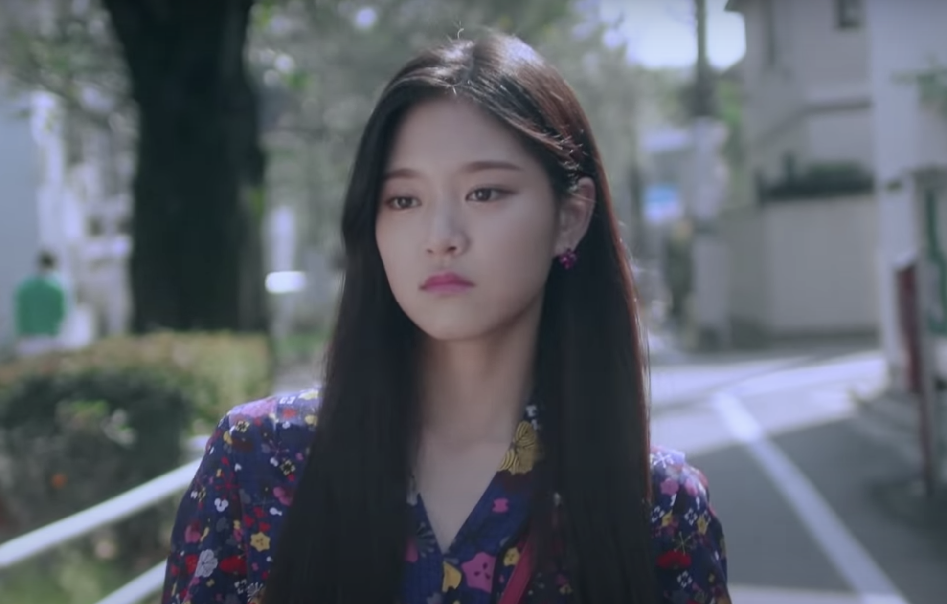 HyunJin walks down the street, frowning slightly