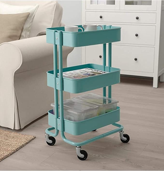 A teal three-tier utility cart