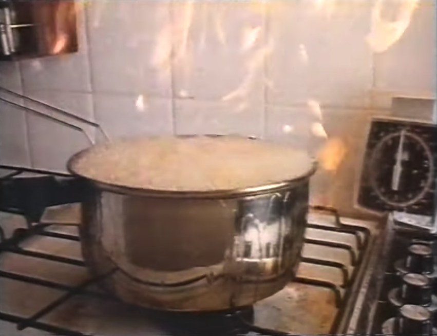 A pot filled with hot oil overfilling; the pot is on fire