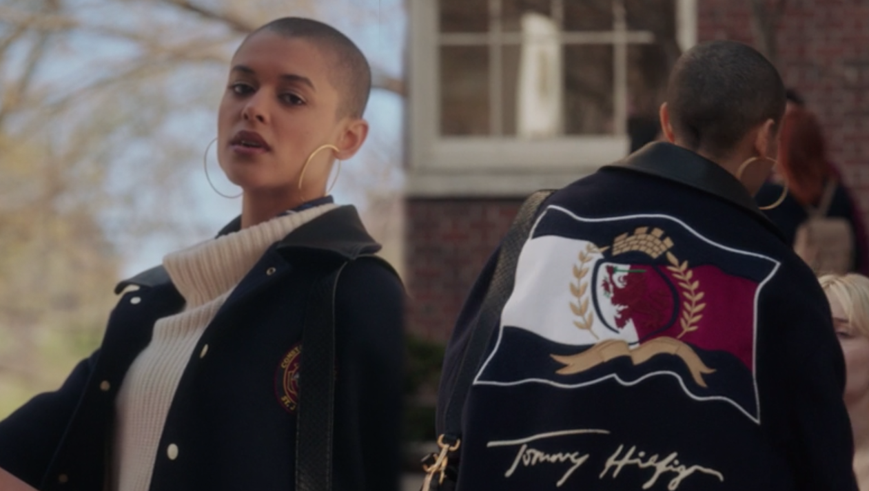 Julien wears an oversized knit sweater under a Tommy Hilfiger letterman jacket