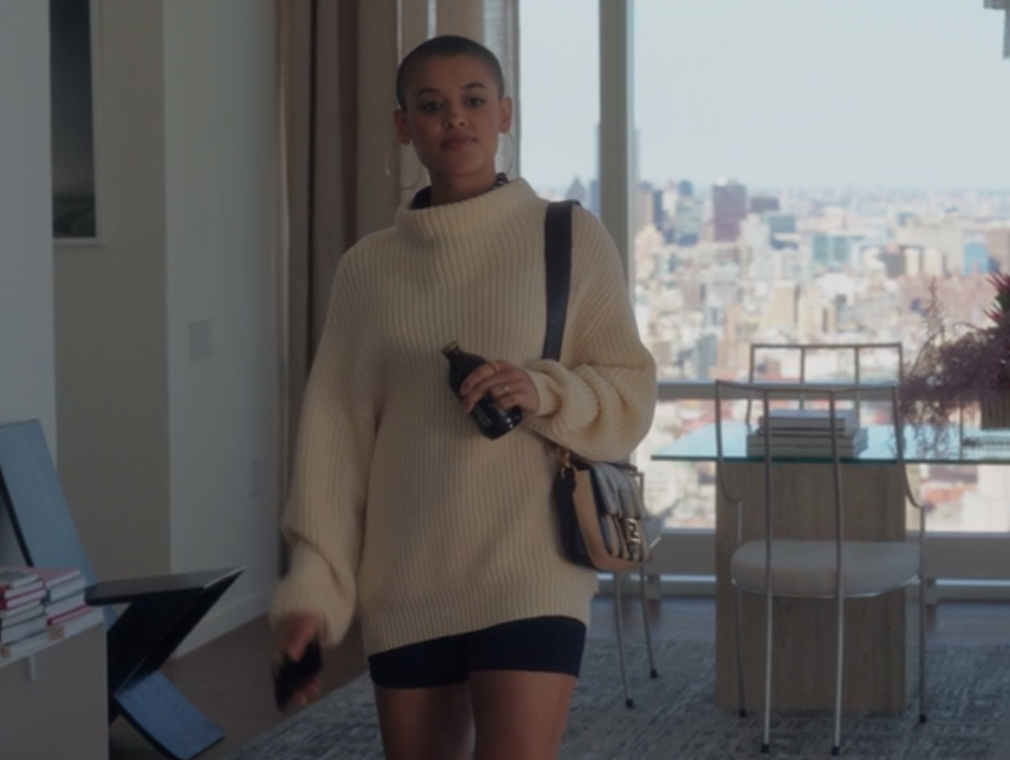 Julien wears a oversized knit sweater over dark biker shorts