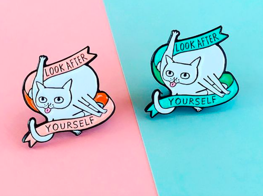 The Look After Yourself Enamel Pin with a cat licking itself in green and pink