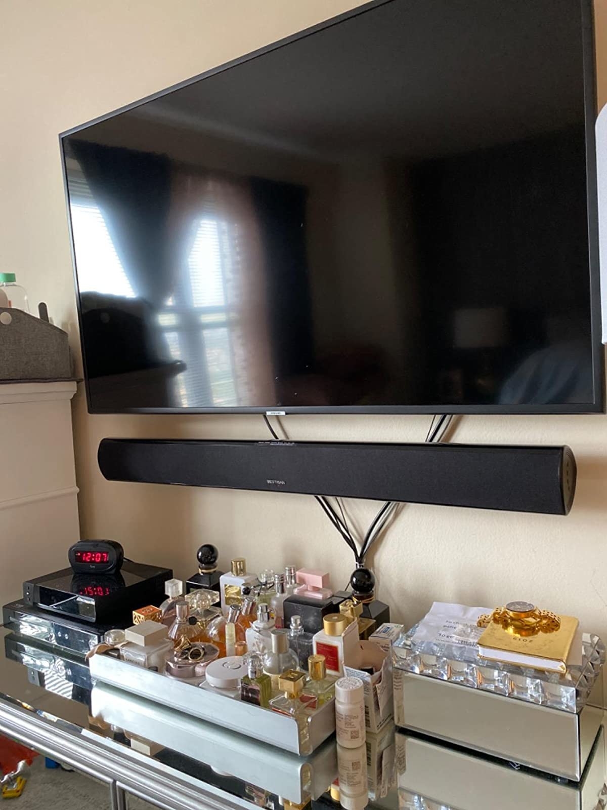 the soundbar mounted to a reviewer&#x27;s wall below a TV