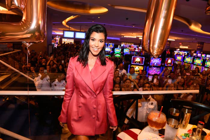 Kourtney posing for a photo at a casino as a crowd looks on