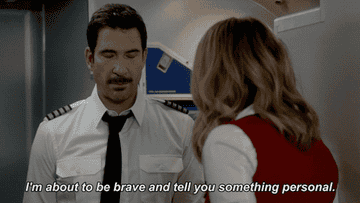 A pilot saying something to flight attendant