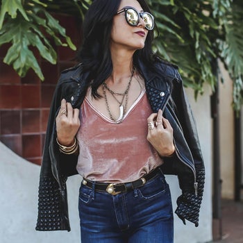 Reviewer in dusty pink velvet strapped tank with a leather jacket on their shoulders 