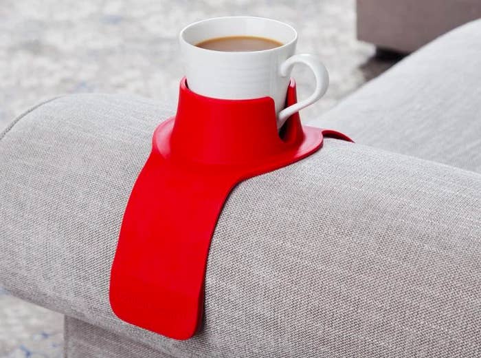 the red weighted silicone holder that looks like a skinny rectangle mat draped over a couch arm. It got a cupholder look in the middle for the cup of course