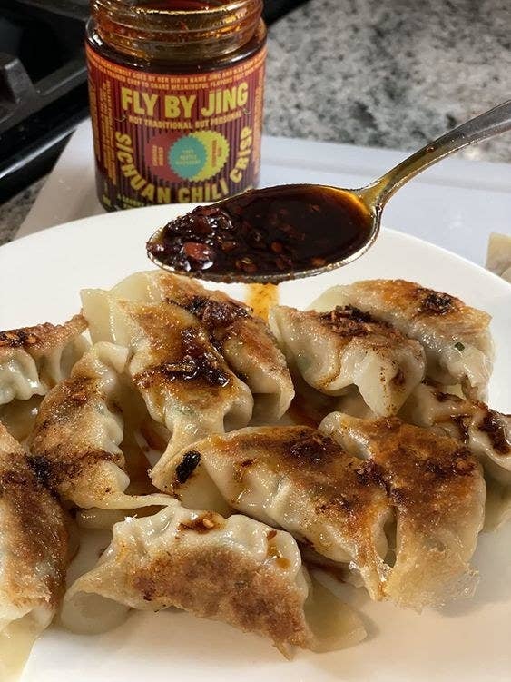 the reviewer's image of the Fly By Jing sichuan chili crisp sauce on dumplings