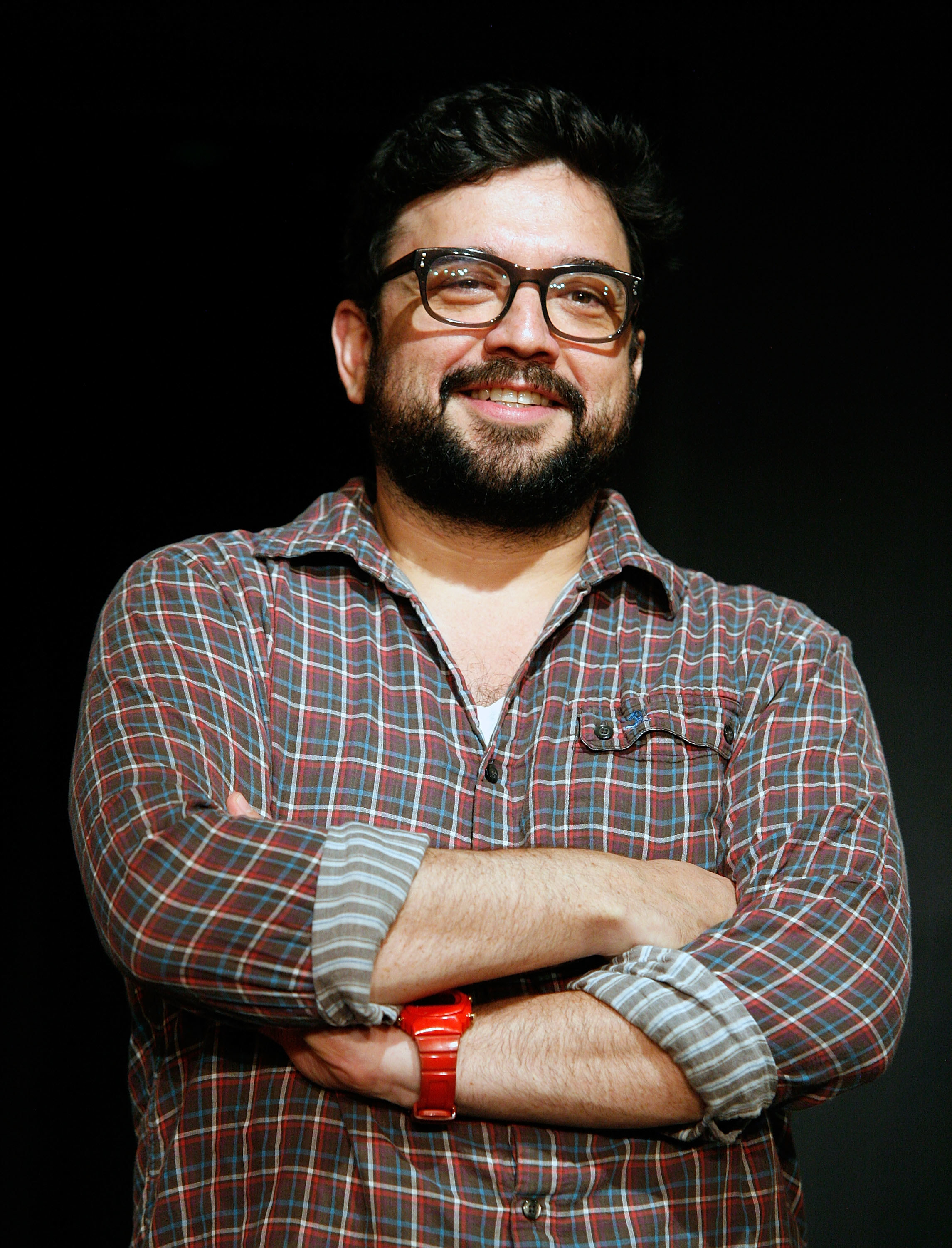 Sanz crosses his arms while wearing a button-down shirt