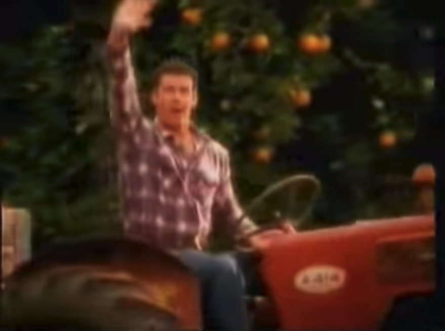 A dad sitting on a tractor waving to his kids