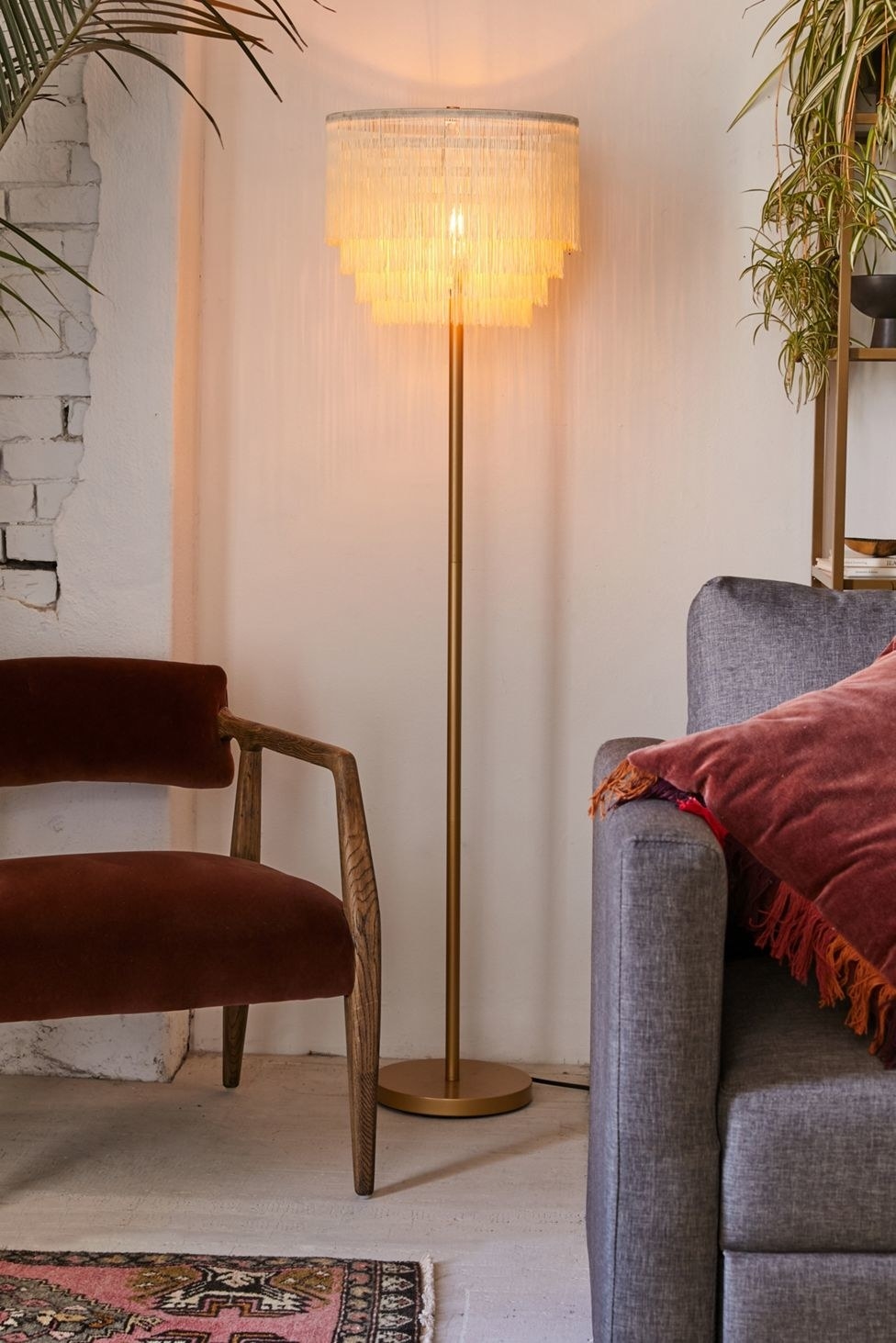the tiered fringe floor lamp turned on in a living room