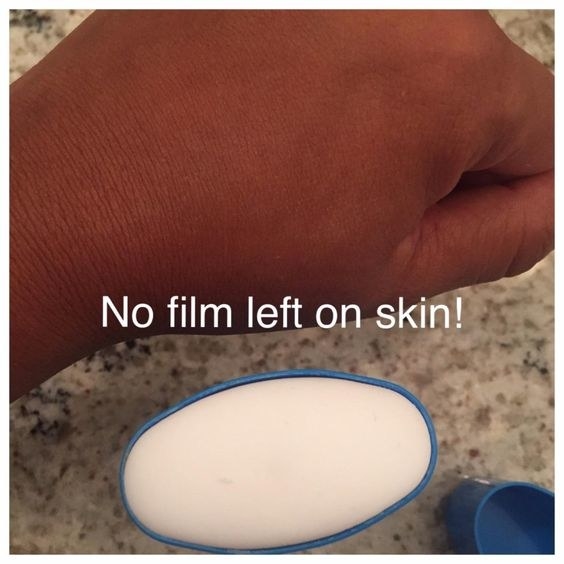 reviewer wearing the balm on their hand with caption &quot;no film left on skin&quot;