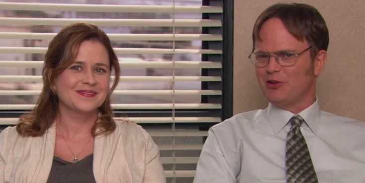 Dwight and Pam sitting by each other and smirking.