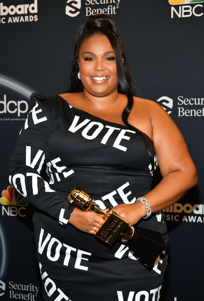 Lizzo smiling for photos while holding her Billboard Music Awards
