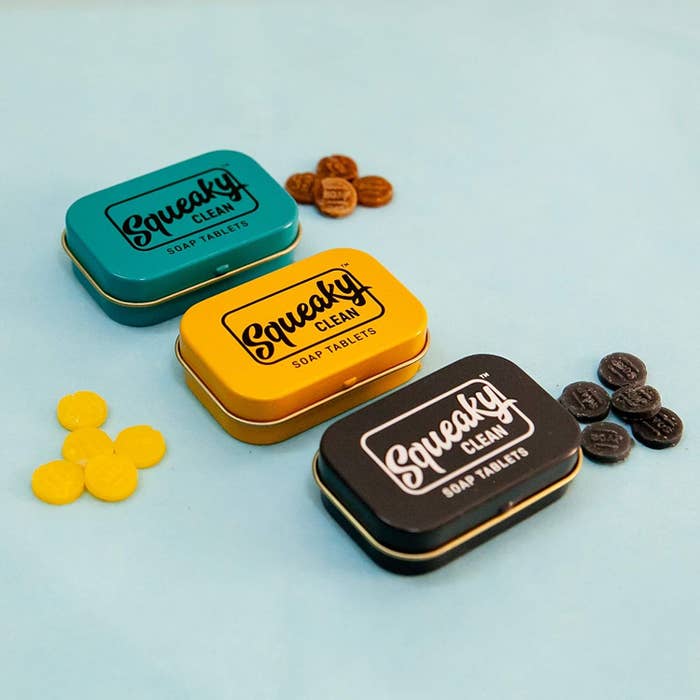 3 different boxes of tiny soap tablets tin boxes in the colours black, yellow and teal