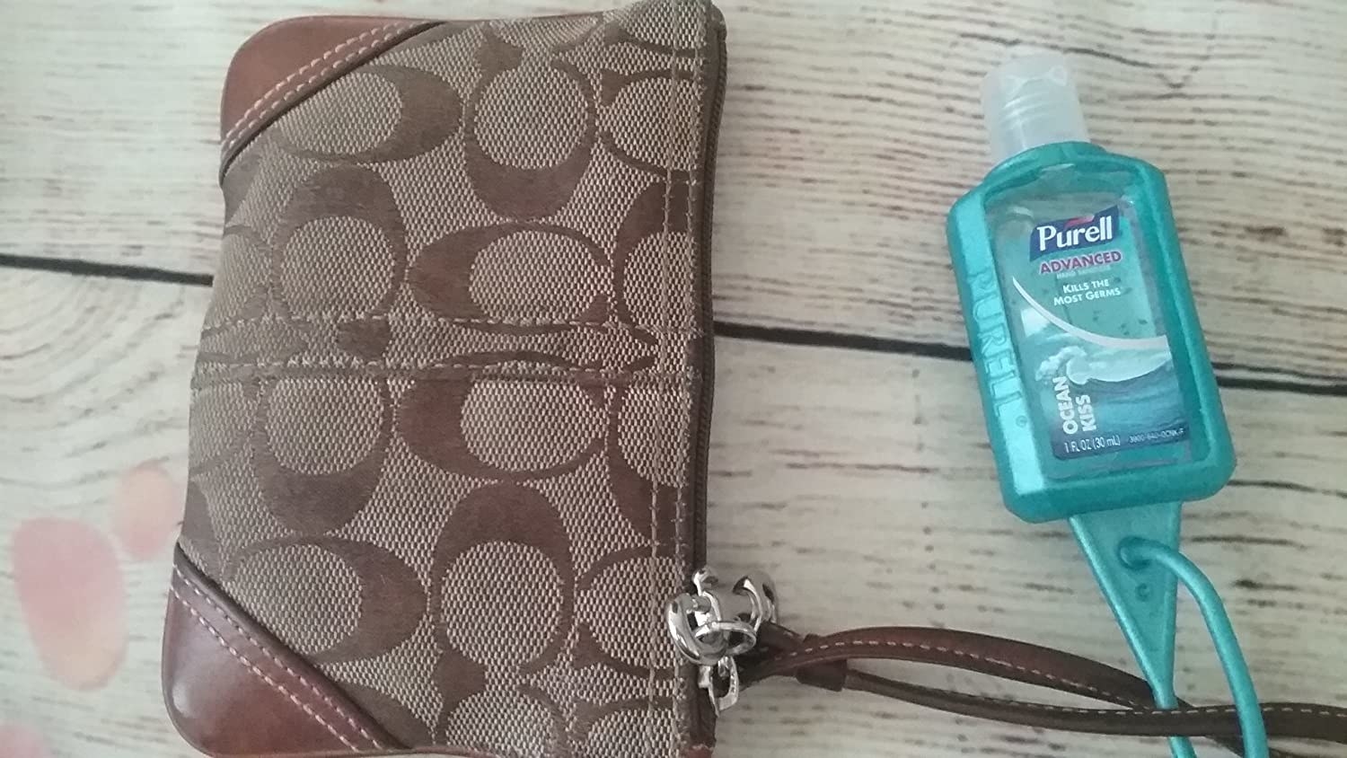 A purell hand sanitser with a jelly wrap attached to a wallet