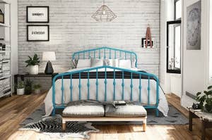 The bed frame in blue, with spindles on the headboard and footboard