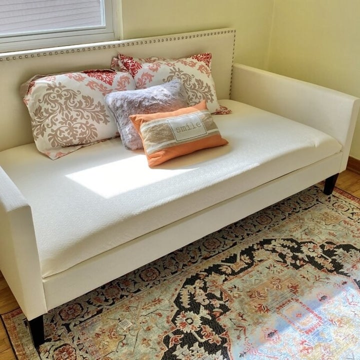 the daybed in white with colorful pillows on it