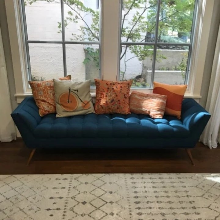 the blue bench with orange pillows