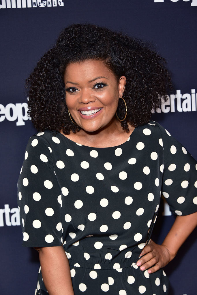 A smiling Yvette on the red carpet, hand on hip