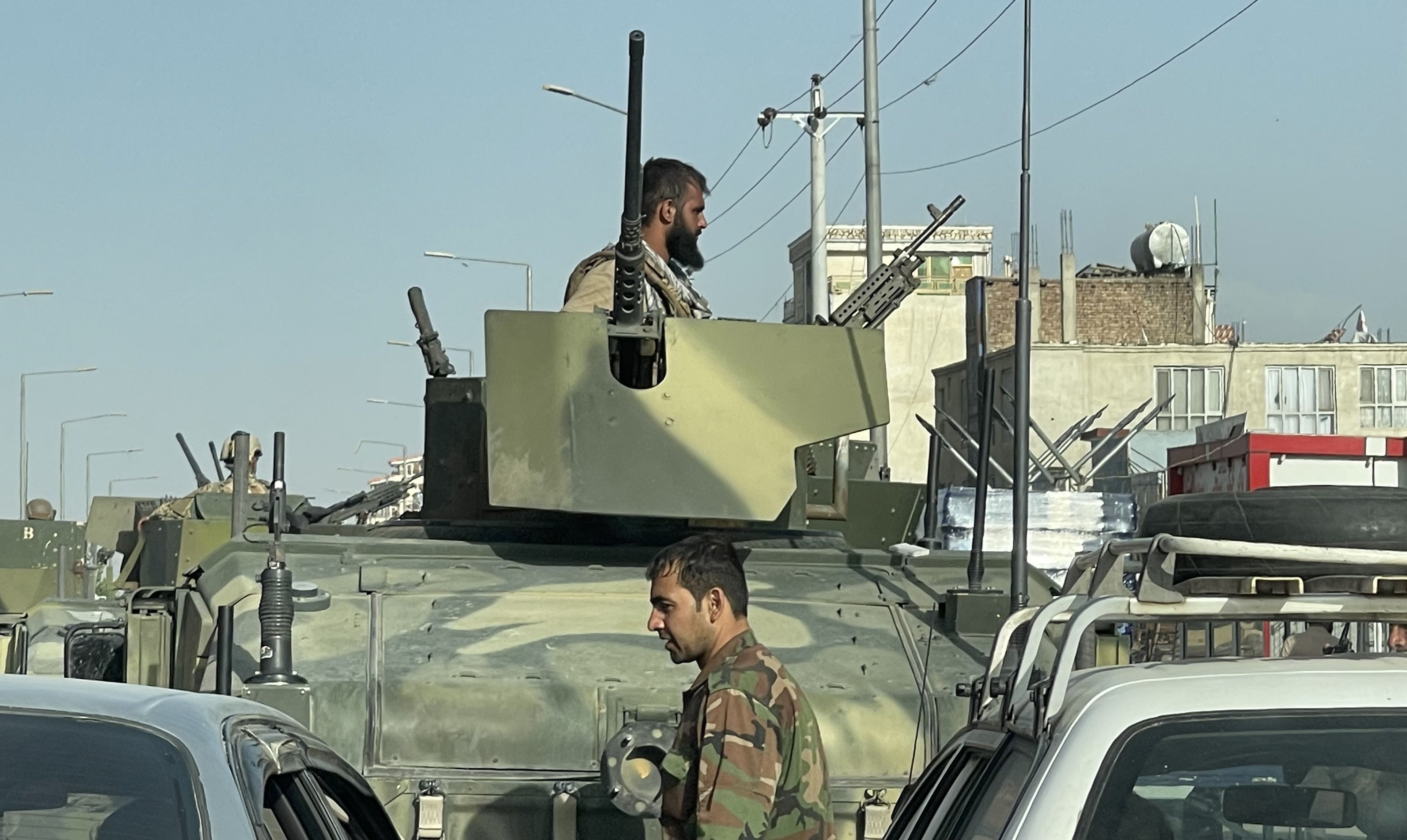 A man appears atop a tank amid traffic