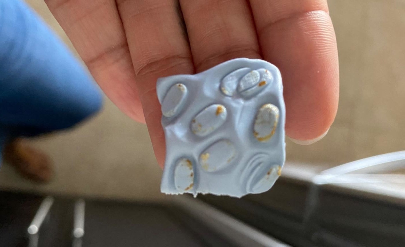 Blue square with lots of ear wax on it that was removed from an AirPod speaker