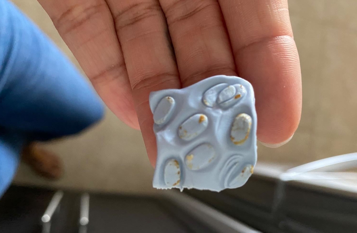 Blue square with lots of ear wax on it that was removed from an AirPod speaker