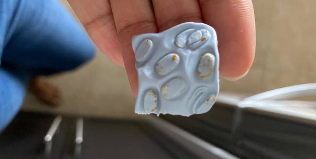 Blue square with lots of ear wax on it that was removed from an AirPod speaker