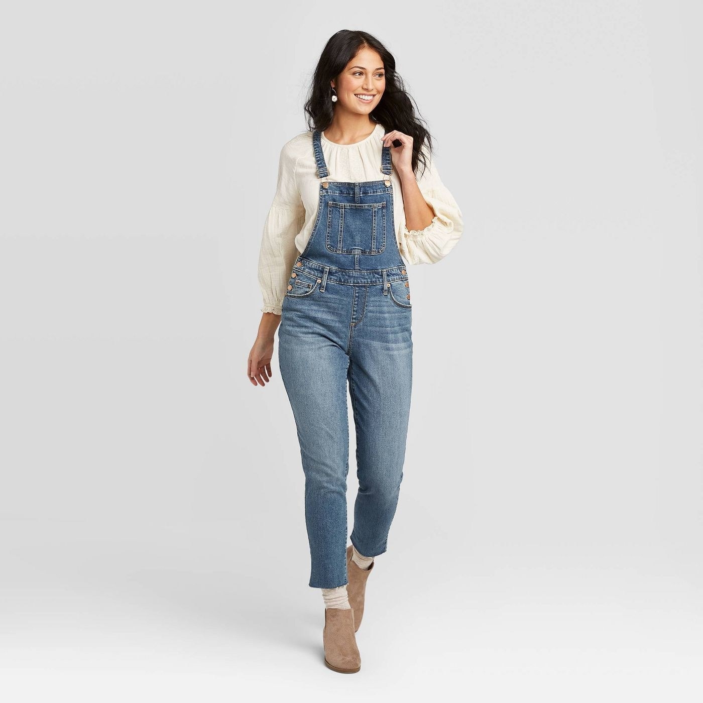 A model wearing a pair of high rise cropped overalls
