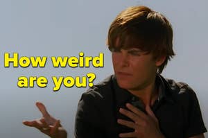 Troy Bolton is holding up his hands labeled, "how weird are you?'