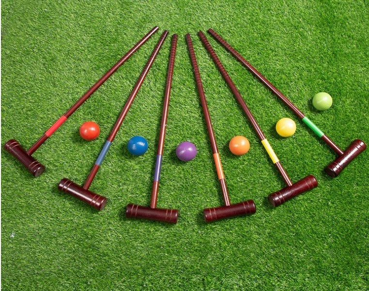 Foto de mazos de madera y pelotas de colores para juego de croquet