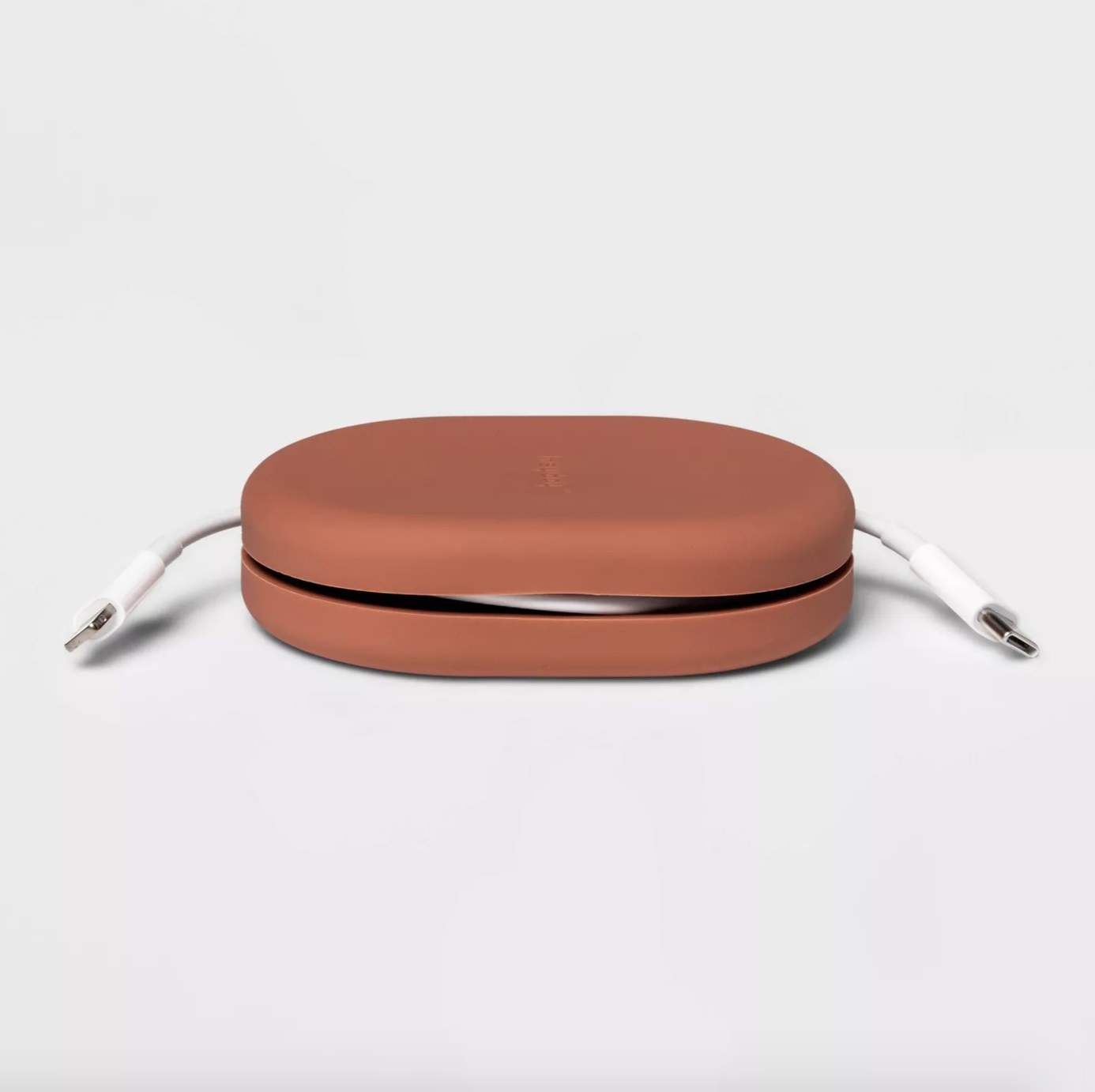 The cedar wood colored silicone cable holder has two lightning bolt edged sticking out