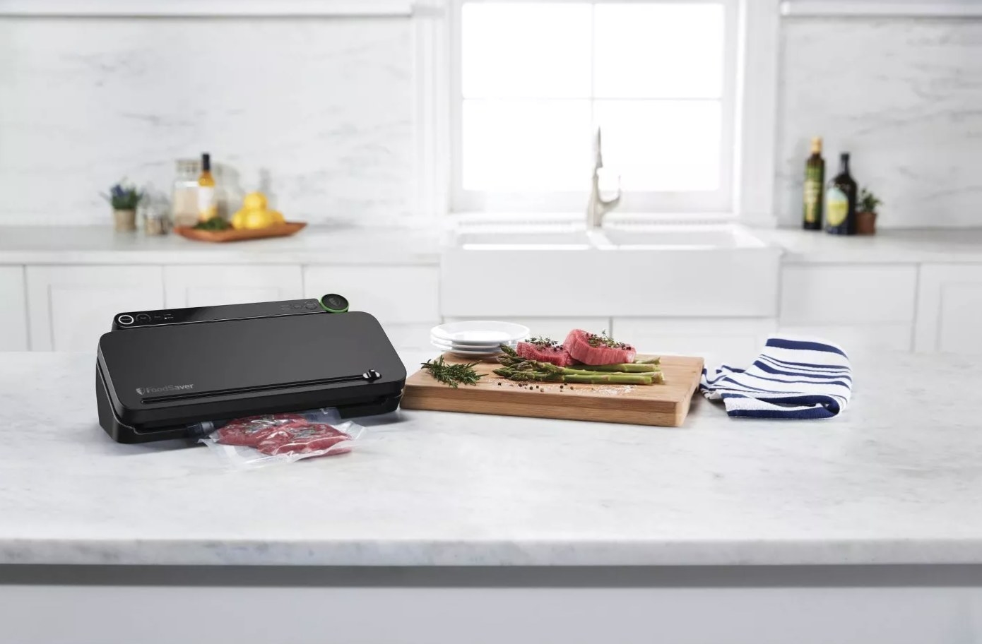 The black vacuum sealer is on a marble countertop and looks to be sealing some raw red meat
