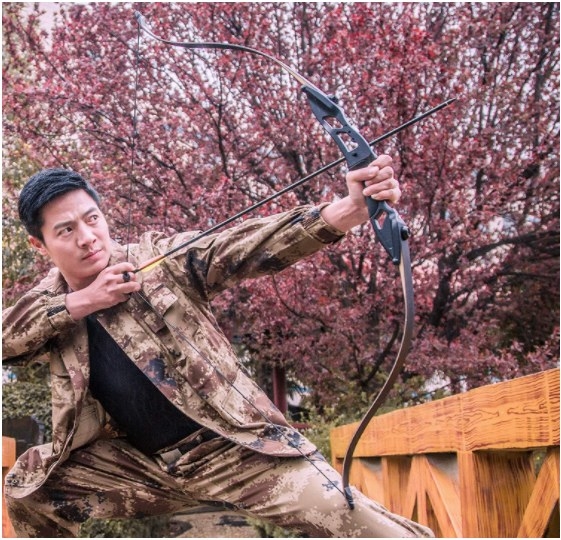 Foto de hombre asiatico sosteniendo un arco con flecha