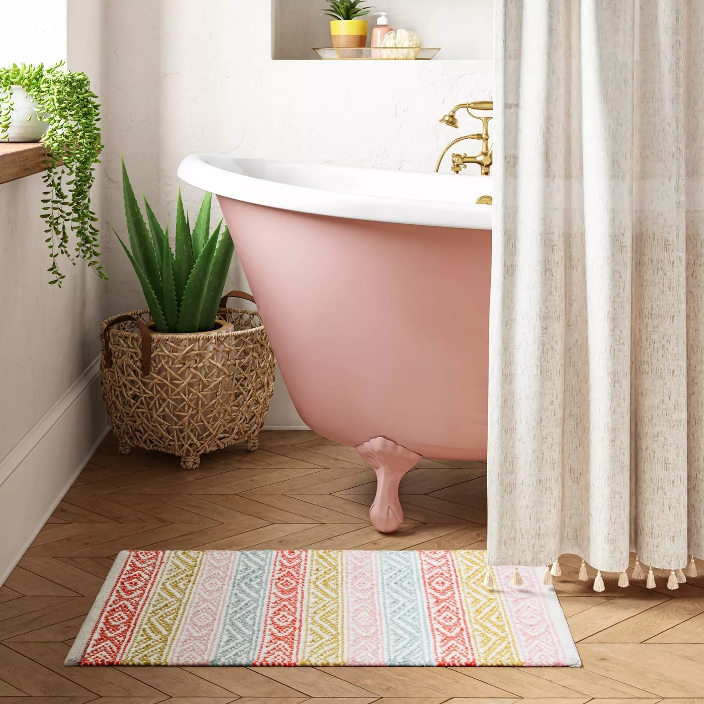 The red, green, pink, and blue striped bath rug in front of a bathroom