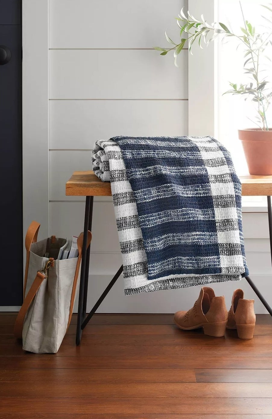 The blue and cream striped throw with gray and cream trim resting on a table