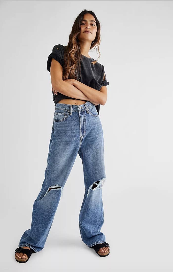 a model wearing the jeans with a t-shirt and sandals