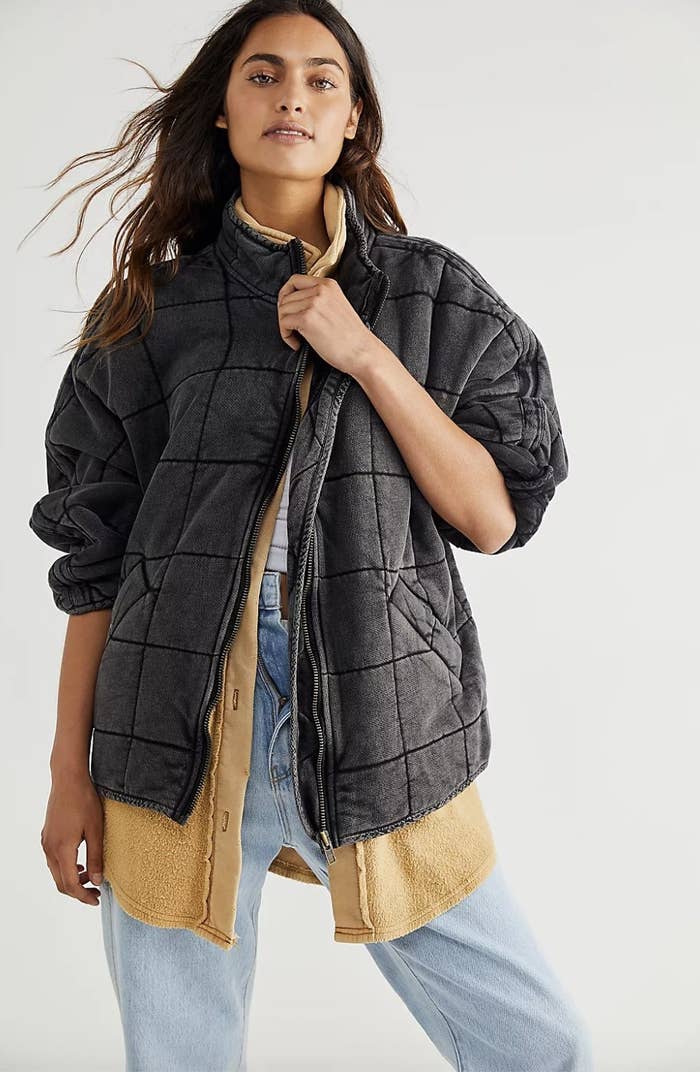 the jacket in black layered over a sweater