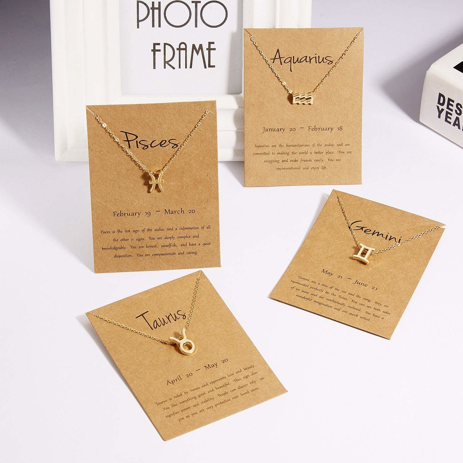 4 different cards holding a different zodiac sign pendant with the dates and a little paragraph about the zodiac