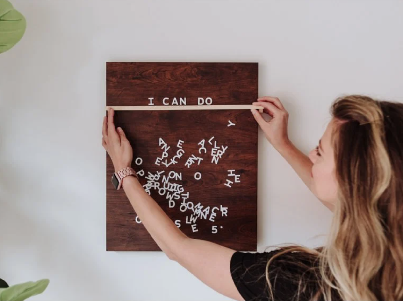 a model arranging a message on the walnut magnetic board