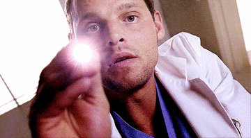 Alex Karev from Grey&#x27;s Anatomy holding up a medical penlight