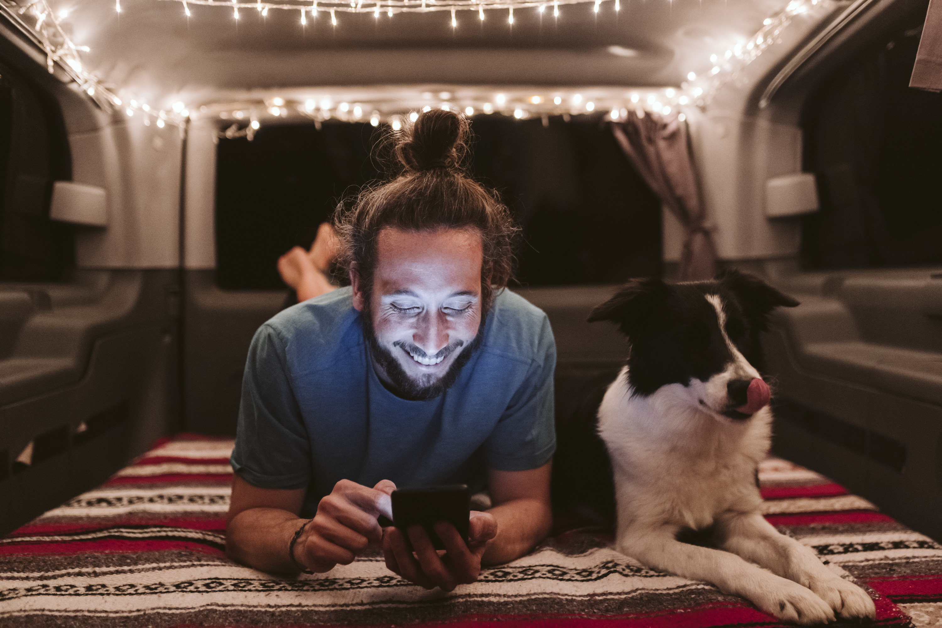 Man relaxing with his dog inside of a camper van