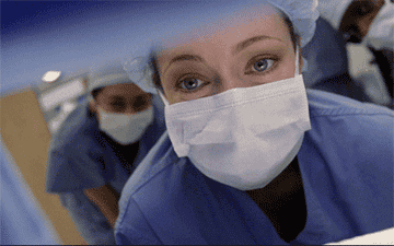 GIF of doctor from Grey&#x27;s Anatomy wearing hair cover and surgical mask