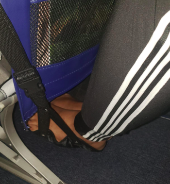 A customer review photo of them using the footrest on an airplane